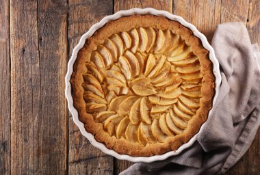 Ahşap arka planda ev yapımı lezzetli elmalı tart.