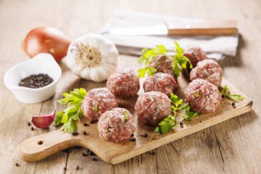 Tahtadaki çiğ köfteler ve bitkiler.