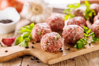Tahtadaki çiğ köfteler ve bitkiler.