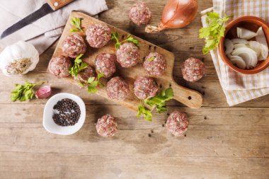 Tahtadaki çiğ köfteler ve bitkiler.