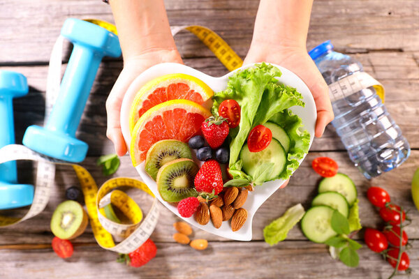 plate of  fruits and vegetables presenting in hand. fitness food, healthy eating, weight loss, dieting concept
