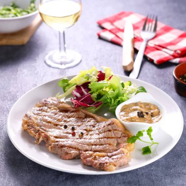 Izgara biftek, biber sosu ve salata.