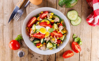 Ton balığı, yumurta, domates ve salatalıklı karışık sebze salatası.