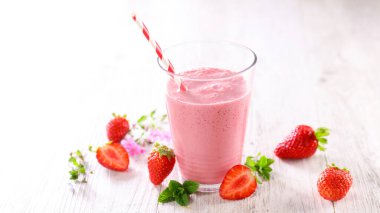 Bir bardak çilekli Smoothie ve pipet.