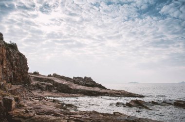 Kayalık, deniz ve dramatik gökyüzü uçurumları ile doğa arka planı
