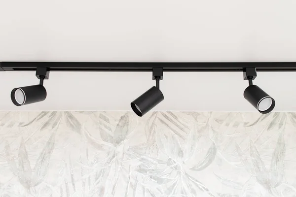 Modern track spot Light on white stretch ceiling in interior.