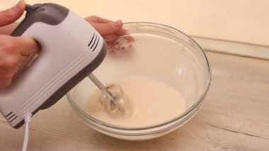 Whisking dough in bowl with a electric mixer