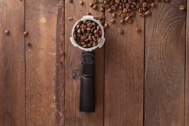 Coffee horn with Ground coffee on wooden background and coffee beans.