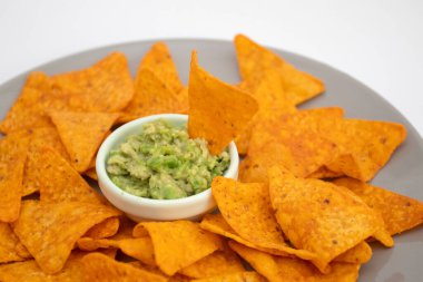 Guacamole sosu ve beyaz arka planda cips.