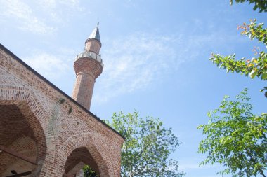Old Minaret of mosque against blue sky.