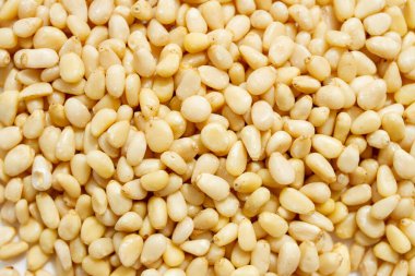 Peeled dried pine nuts as background.