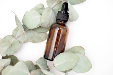 Essential oil bottle with a pipette and eucalyptus leaves