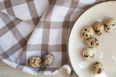 Easter Quail eggs on a beige plate.