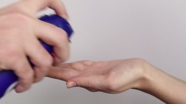 Hands squeezing shaving foam on hand.