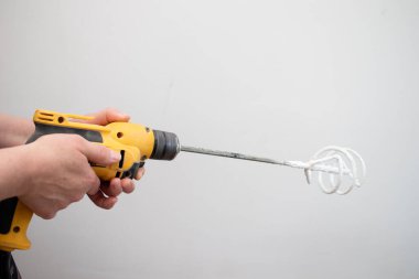 Elle havan karıştırıcı tutan inşaatçı.