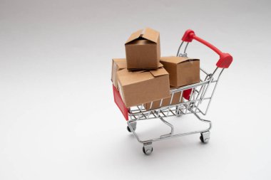 Küçük bir alışveriş arabasında karton kutular. İnternetten alışveriş.