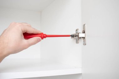 İşçi gardırop kapısını menteşeye viş ediyor..