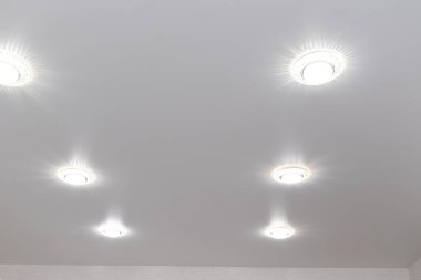 Tavan lambaları beyaz gerilmiş tavanda.