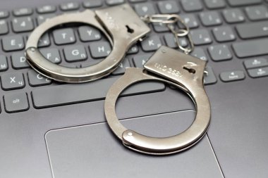 İnternet dolandırıcılığı. Kelepçeler klavyede.