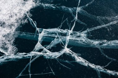 Kışın Baykal Gölü 'nde çatlakları olan şeffaf mavi buz. Soyut kış doğası geçmişi. Baykal, Sibirya, Rusya.