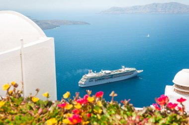 Santorini Adası, Yunanistan 'da beyaz mimari. Terasta deniz manzaralı çiçekler. Seyahat ve yaz tatili kavramı