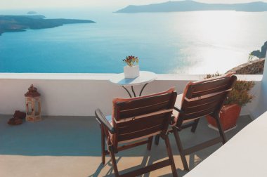 Santorini Adası, Yunanistan 'da beyaz mimari. Terasta deniz manzaralı iki sandalye. Seyahat hedefi kavramı