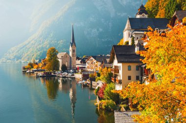 Avusturya Alpleri 'ndeki Hallstatt köyü. Evler ve dağlar göle yansıyor. Güzel sonbahar manzarası