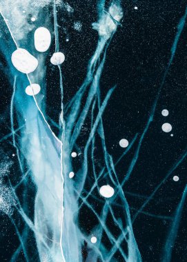 Kışın Baykal Gölü 'nde çatlak ve kabarcıklı şeffaf mavi buz. Soyut kış doğa arkaplanı. 