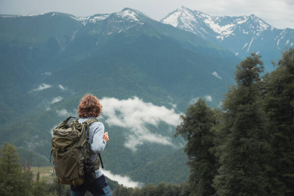 Man traveler with backpack hiking in the mountains. Summer landscape. Travel and outdoor activity concept