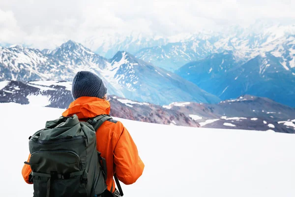 stock image Man traveler with backpack hiking in winter mountains. Travel and outdoor activity concept