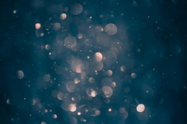 Pink lights bokeh background. Abstract blurred glowing lights on dark blue background..