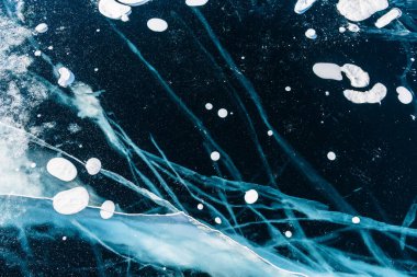 Kışın Baykal Gölü 'nde çatlak ve kabarcıklı şeffaf mavi buz. Soyut kış doğa arkaplanı. 