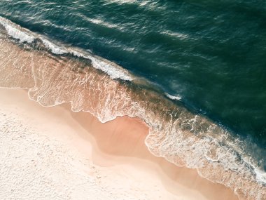 Waves on the sea coast. Beach with white sand and the blue sea. Aerial top down view.