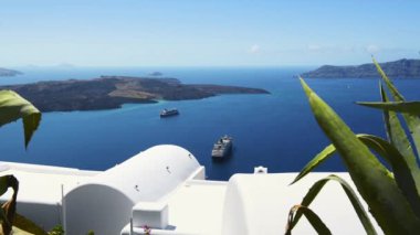 Santorini Adası, Yunanistan 'da beyaz mimari. Mavi deniz ve mavi gökyüzü. Lüks tatil köyü. Adanın yakınındaki bir yolcu gemisinde. Seyahat ve yaz tatili konsepti