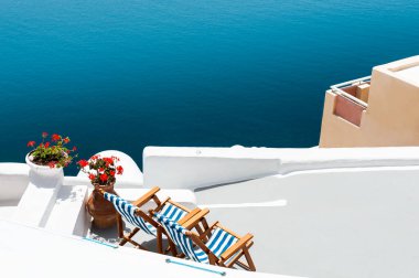 Santorini Adası, Yunanistan. Terasta deniz manzaralı şezlonglar. Seyahat ve tatil kavramı