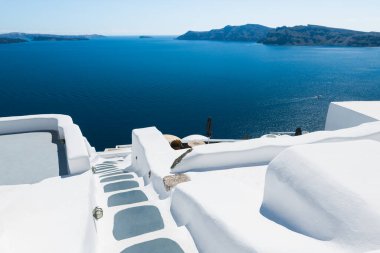 Santorini Adası, Yunanistan 'da beyaz mimari. Deniz manzaralı lüks bir otel. Denize giden merdivenler. Seyahat ve tatil kavramı