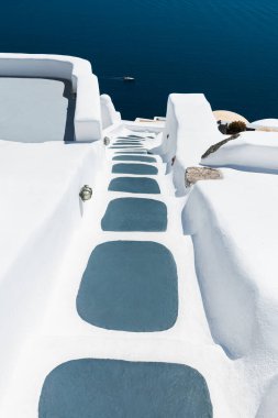 Santorini Adası, Yunanistan 'da beyaz mimari. Deniz manzaralı lüks bir otel. Denize giden merdivenler. Seyahat ve tatil kavramı