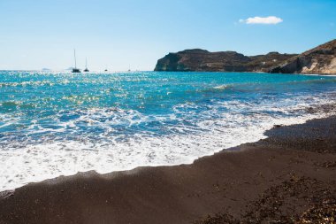 Yunanistan 'ın Santorini adasındaki kırmızı plaj. Siyah volkanik kum ve mavi deniz. Güneşli bir günde yaz deniz manzarası