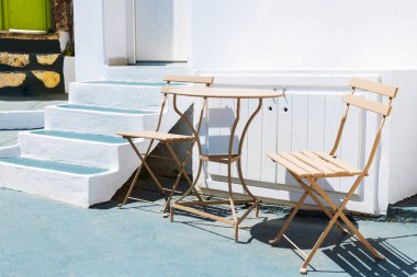 Yunanistan 'ın Santorini adasında beyaz sikladik mimari. Konforlu terasta masalı iki sandalye