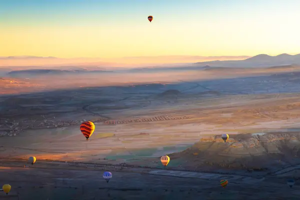 Colorful hot air balloons over the mountains in Cappadocia, Turkey. Beautiful landscape at sunrise. Famous travel destination.