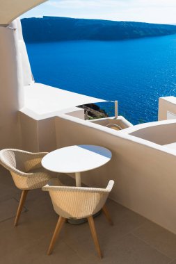 Santorini Adası, Yunanistan 'da beyaz mimari. Deniz manzaralı güzel bir teras. Seyahat ve yaz tatili konsepti
