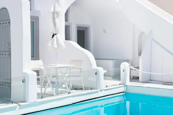 stock image White architecture in Santorini island, Greece. Luxury swimming pool with blue water. Travel and vacation concept