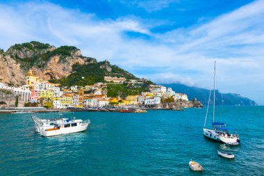 Amalfi Sahili, İtalya. Kayaların üzerinde renkli mimarisi olan Amalfi kasabasının güzel manzarası. Deniz kıyısındaki yatlar. 