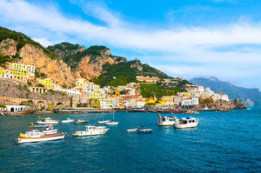 Amalfi Sahili, İtalya. Kayaların üzerinde renkli mimarisi olan Amalfi kasabasının güzel manzarası. Deniz yatları kıyıya yakın