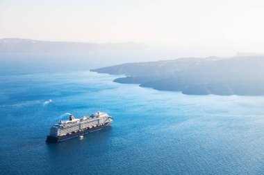 Santorini Adası, Yunanistan. Kıyıya yakın bir gemi turu. Mavi deniz ve mavi gökyüzü gün batımında. Seyahat ve tatil kavramı