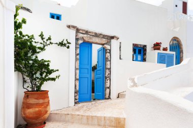 Yunanistan 'ın Santorini adasında beyaz sikladik mimari. Çiçekli rahat bir sokak. 