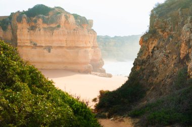 Portekiz, Algarve 'deki Atlantik Okyanusu kıyısındaki kayalar. Güneşin doğuşuyla güzel yaz manzarası
