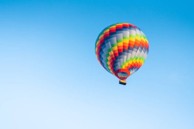 Güneşli bir günde mavi gökyüzüne karşı renkli sıcak hava balonu. Gökyüzünde güzel gökkuşağı balonu 