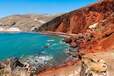 Yunanistan 'ın Santorini adasındaki kırmızı plaj. Kızıl volkanik kayalıklar ve güneşli bir günde mavi deniz. Meşhur seyahat yeri