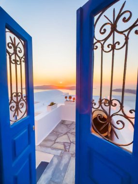 Santorini Adası, Yunanistan 'da beyaz mimari. Gün batımında deniz manzaralı güzel bir teras. Seyahat ve yaz tatili konsepti